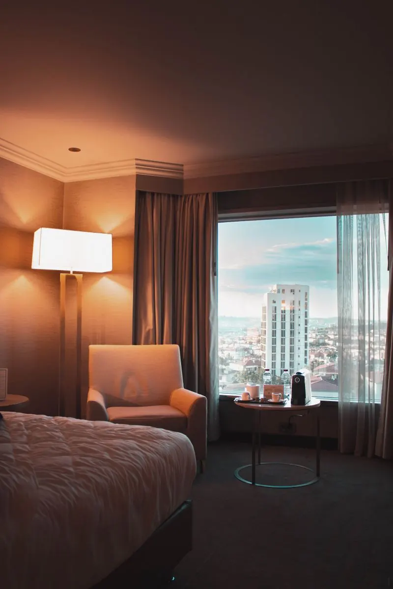 Habitación de hotel boutique con luz cálida y vistas a la ciudad